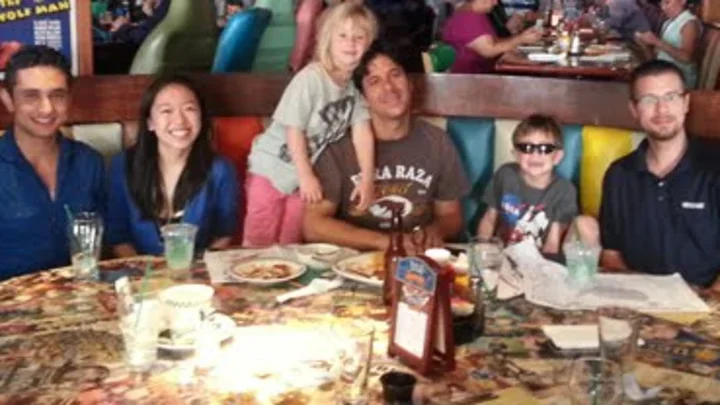 Claire Huang and young kids having a meal with Dr. Portera. 