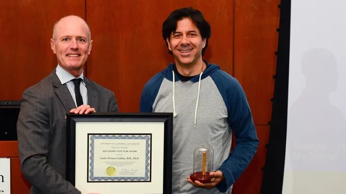 Carlos & Tom holding an award, smiling at Science Day in 2023.