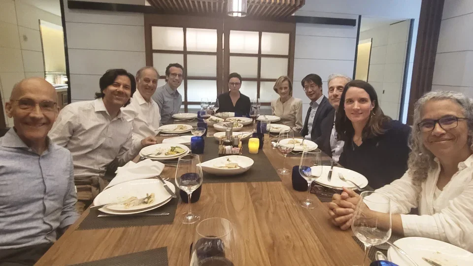 Group of researchers sitting around a table, eating a meal at Fuster Symposium.
