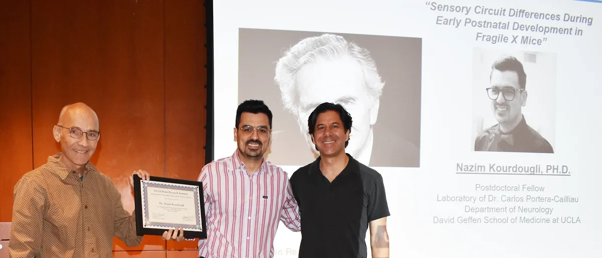 Nazim Scheibel standing with Dr. Portera-Cailliau and another researcher to celebrate prize during January 2024.