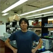 Adrian Cheng, PhD, standing in lab.