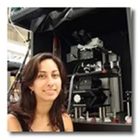 Tara Chowdhury in front of microscope at lab.