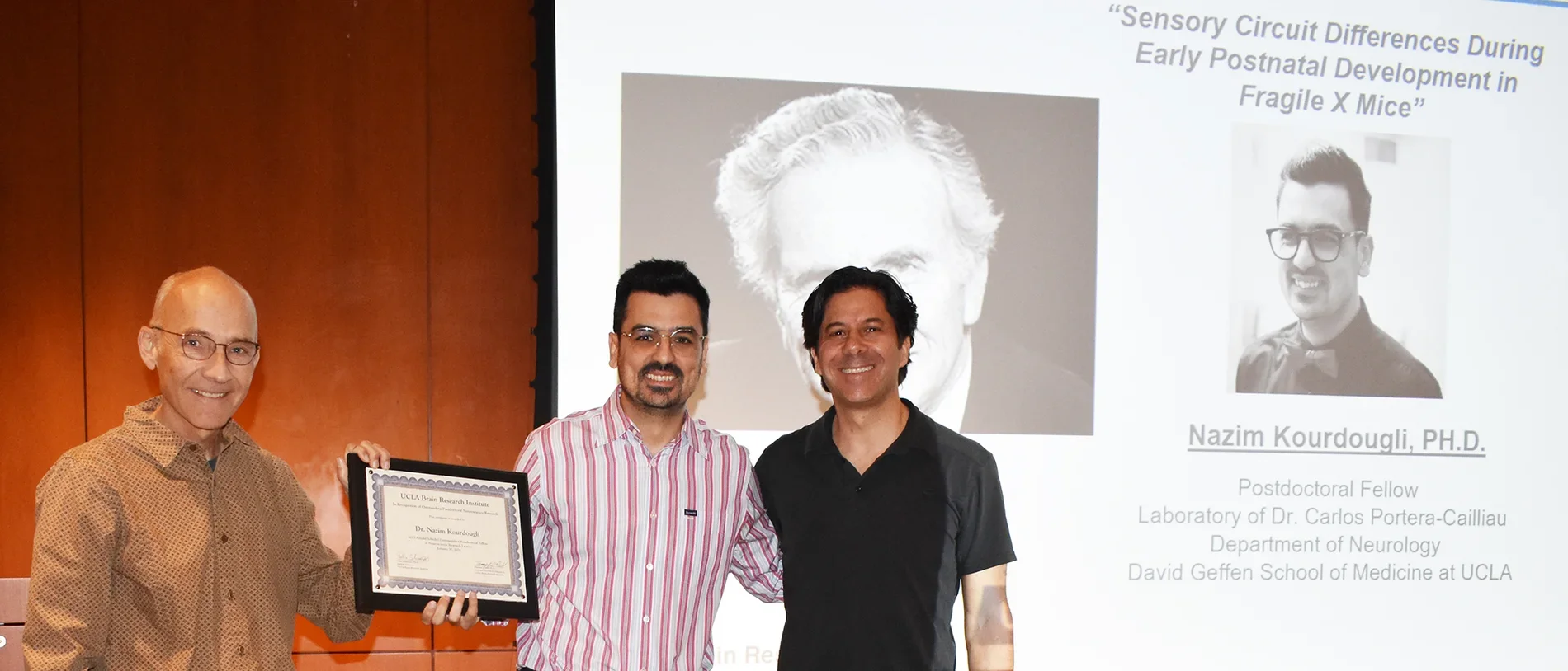 Nazim Scheibel standing with Dr. Portera-Cailliau and another researcher to celebrate prize during January 2024. 